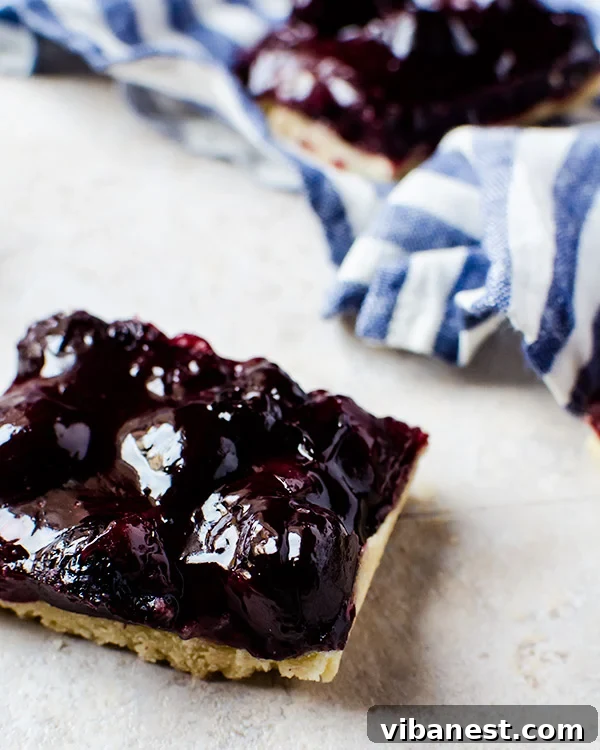 Close-up of baked Cherry Pie Bars, showcasing the vibrant filling and golden crust.