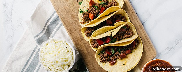 Delicious slow cooker beef tacos prepared and ready to serve on a rustic wooden board with fresh toppings