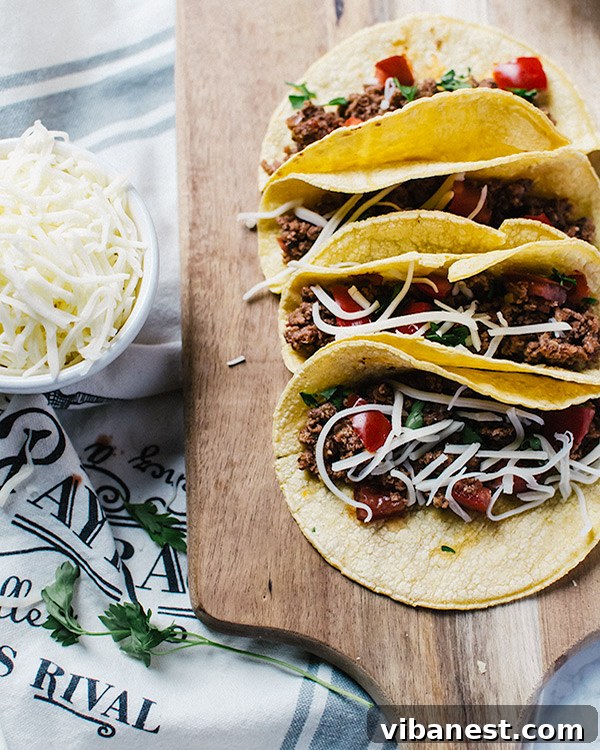 Slow Cooker Beef Tacos - Filling Close-up of shredded slow cooker beef taco meat in a white bowl with a spoon, ready for serving