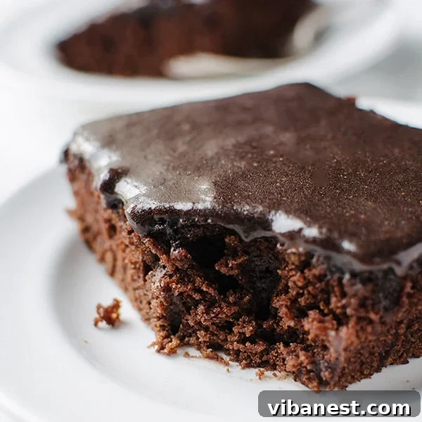 Freshly baked Coca-Cola cake being drizzled with warm cola frosting