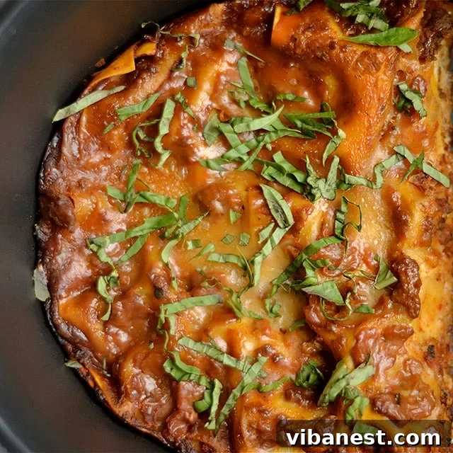 Slow Cooker Lasagna Served A serving of slow cooker lasagna on a plate, garnished with fresh basil