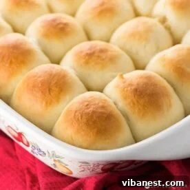 Top-Tier Thanksgiving Side Dishes 4 Freshly baked, golden-brown dinner rolls in a baking dish, brushed with butter, ready to serve.