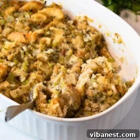 Top-Tier Thanksgiving Side Dishes 6 A golden-brown casserole dish filled with savory turkey stuffing, garnished with fresh herbs, a classic Thanksgiving staple.