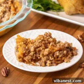 Top-Tier Thanksgiving Side Dishes 7 A bowl and a plate of creamy sweet potato casserole topped with a crunchy pecan streusel, a rich and sweet Thanksgiving side.