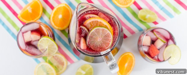 party-pitcher-sangria Full pitcher of virgin sangria ready to be served at a lively party, alongside a bowl of assorted fresh fruits