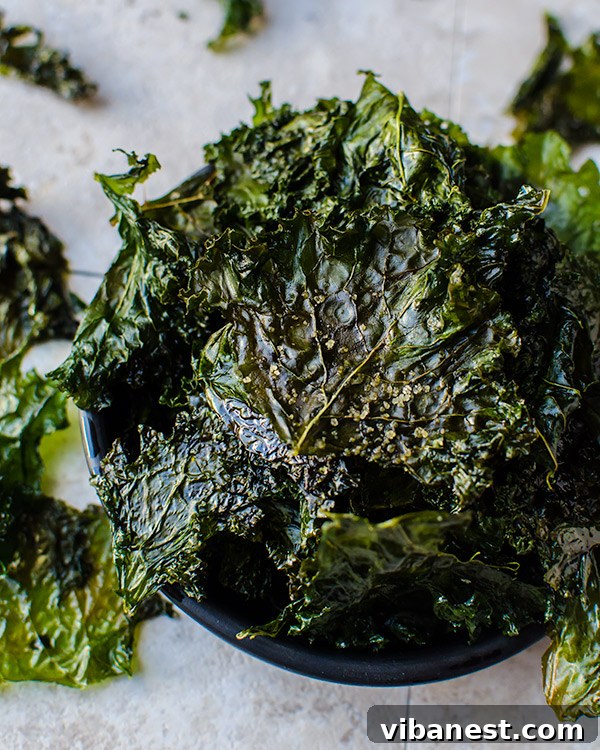 Prepping Kale for Crispy Chips: The Essential Steps Fresh kale leaves being massaged with olive oil on a baking sheet, ready for the oven
