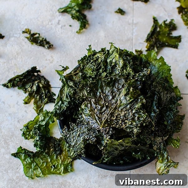 A vibrant bowl filled with freshly baked crispy kale chips, seasoned perfectly
