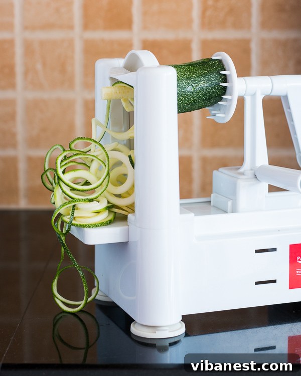 Using a Countertop Spiralizer for Zucchini Noodles A countertop spiralizer in action with zucchini