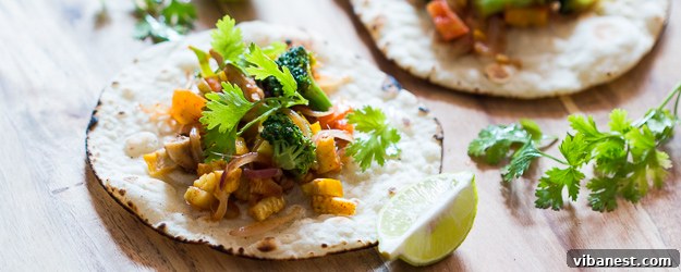 Vibrant healthy vegetarian tacos generously filled with fresh vegetables and cheese, ready to be served on a rustic wooden board.