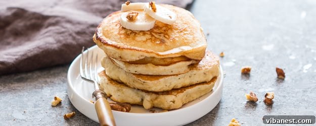Serve your easy banana pancakes with your favorite toppings for a delightful meal. Close-up of a stack of easy banana pancakes with syrup and a fork, ready to be eaten