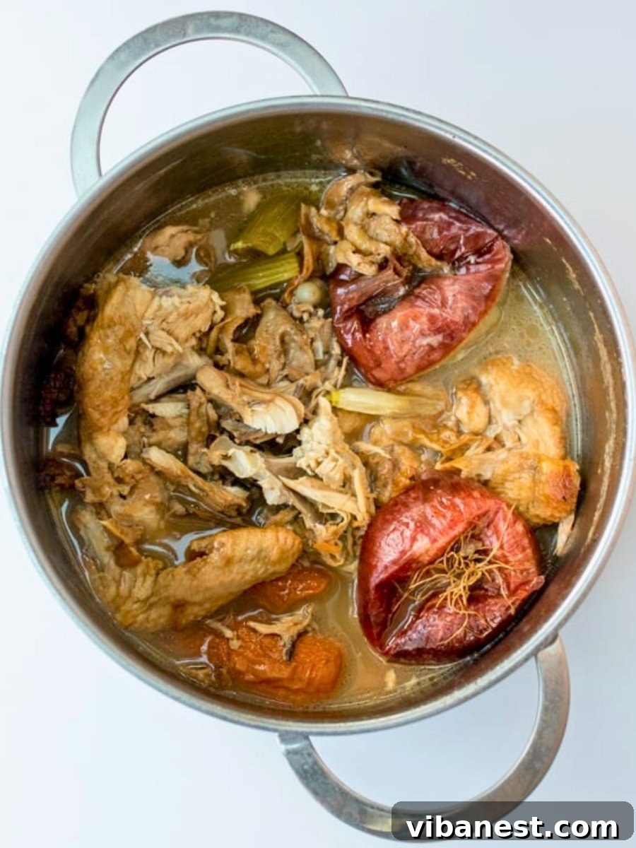 Mastering Homemade Chicken Stock 7 A large pot of chicken stock after it has simmered for 6 hours, ready for straining.