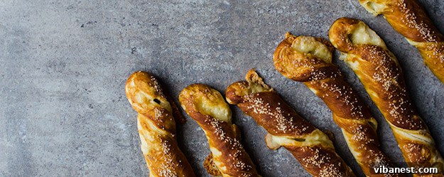 Golden brown cheesy pretzel twists artfully arranged on a cooling rack, tempting and delicious.