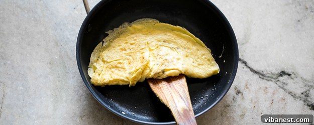 Perfectly cooked omelet in a non-stick pan, ready to be folded