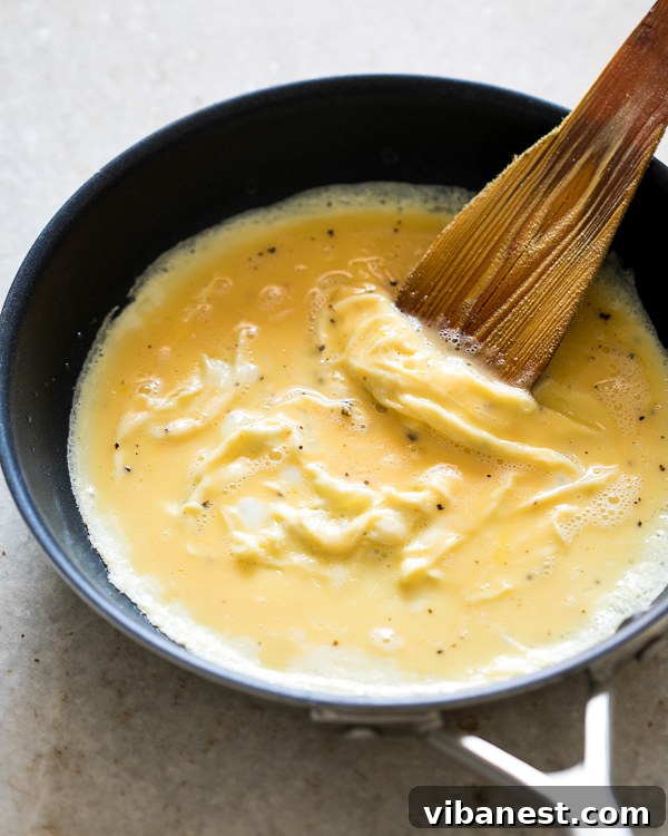 How to make an omelet: Adding your favorite fillings Omelet being filled with cheese and herbs, ready for folding