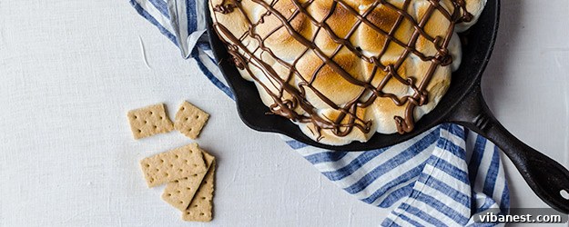 Delicious S'mores Nachos with toasted marshmallows, melted chocolate, and graham crackers in a cast iron skillet, ready to be served