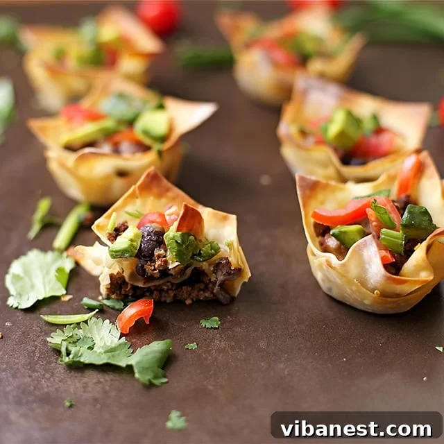 beef-taco-cups-3.jpg Freshly baked beef taco cups with toppings ready to serve.