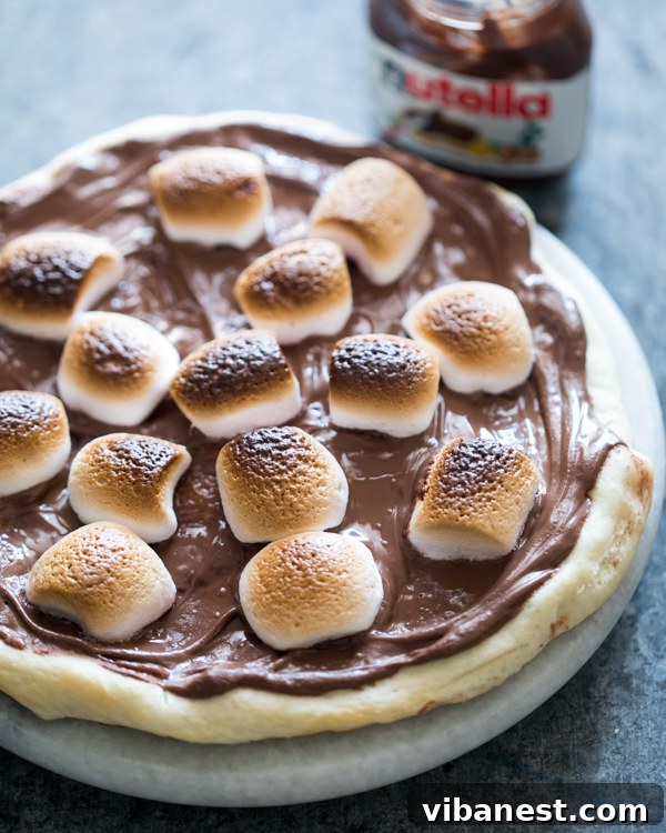 S'mores Chocolate Pizza - Irresistible Close Up Close-up of a S'mores Chocolate Pizza featuring perfectly golden-brown marshmallows and rich melted Nutella