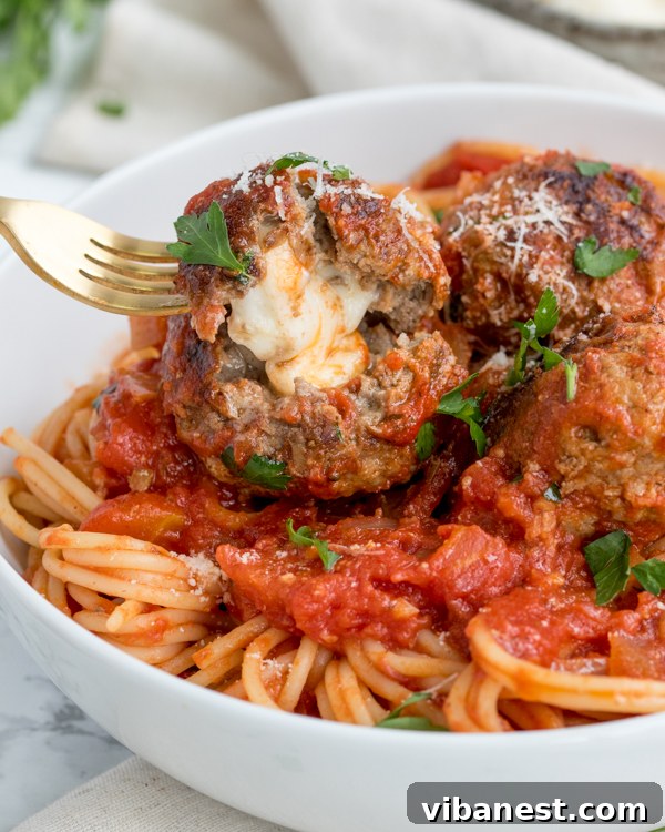 mozzarella-stuffed-meatballs-2.jpg Close-up of golden brown mozzarella stuffed meatballs in a pan