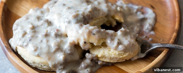 Breakfast Gravy on a Biscuit Close-up of a biscuit cut in half, drenched in creamy sausage gravy, perfect for a cozy breakfast.