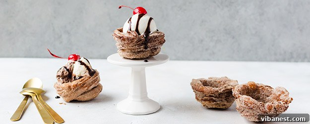 Delicious golden-brown churro ice cream bowl filled with creamy vanilla ice cream, topped with sprinkles and a drizzle of caramel sauce.