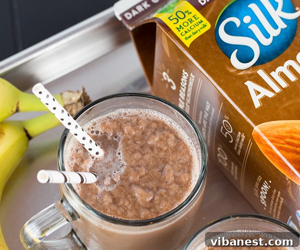 Creamy Chocolate Almond Milk Freeze Close-up of a frosty glass of chocolate almond milk freeze, showcasing its creamy, thick texture and a straw for easy sipping.