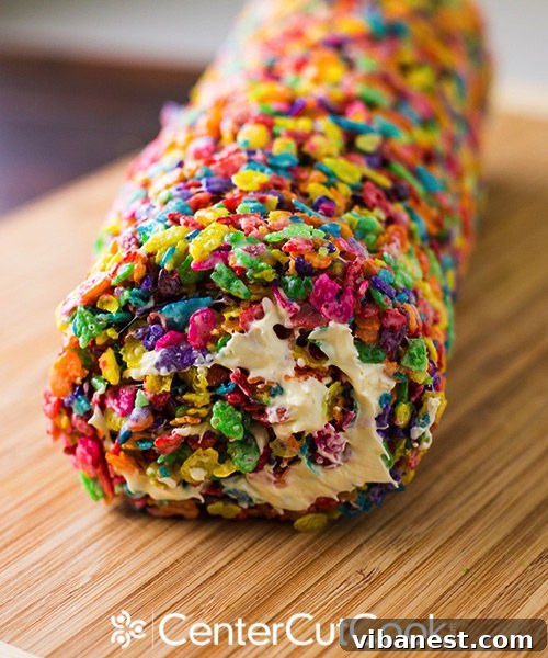 Rolling the Fruity Pebbles Pinwheel Log Step-by-step image of rolling the frosted Fruity Pebbles treat into a firm, colorful log