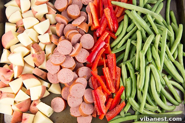 one-pan-sausage-potatoes-2.jpg Ingredients for one-pan sausage and potatoes laid out on a cutting board