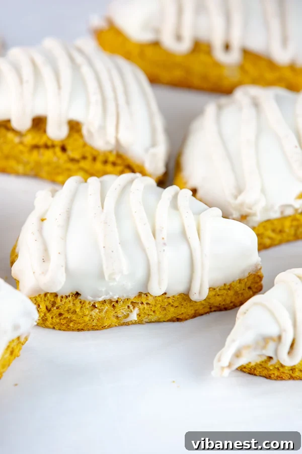 Three golden brown homemade pumpkin scones cooling on a rack, ready for glazing