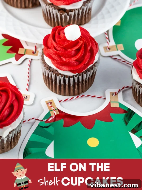 Elf-on-the-Shelf-Cupcakes-Detail Close-up of a decorated Elf on the Shelf cupcake, showcasing the red hat frosting and marshmallow detail.