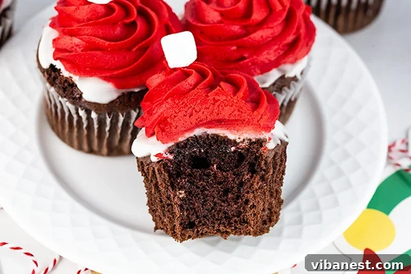 Elf-on-the-Shelf-Cupcakes-Arrangement Three Elf on the Shelf cupcakes arranged neatly, showcasing their vibrant red frosting and white marshmallow tops.