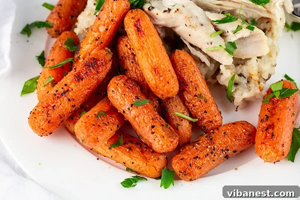 oven-roasted-baby-carrots-4.jpg A close-up shot of roasted baby carrots with visible seasoning and glossy sheen.