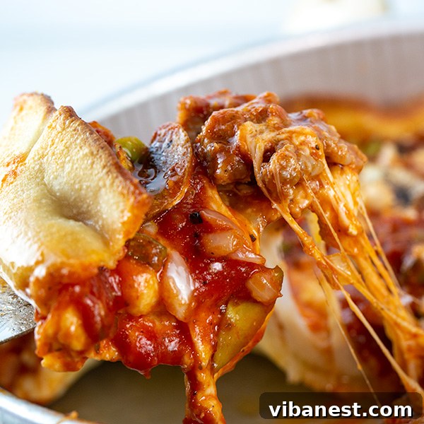 Close-up of a perfectly baked Chicago-Style Deep-Dish Brat Pizza slice