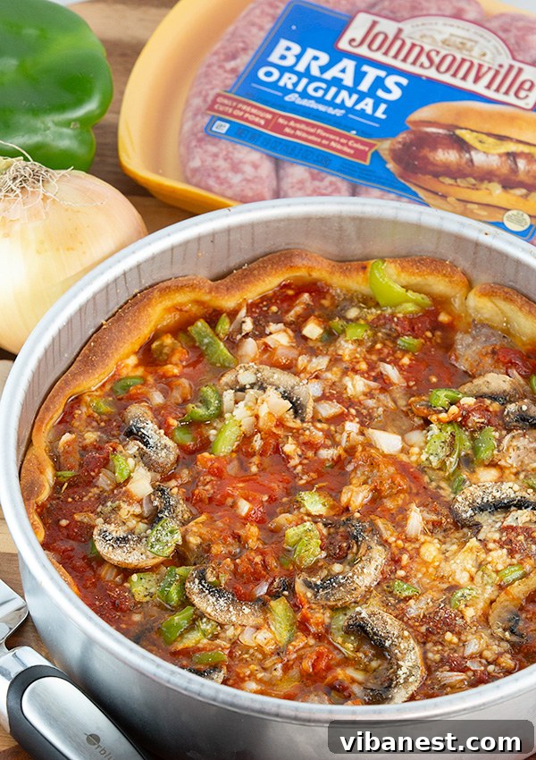 Slice of Chicago Deep-Dish Brat Pizza showcasing thick layers of cheese and sausage
