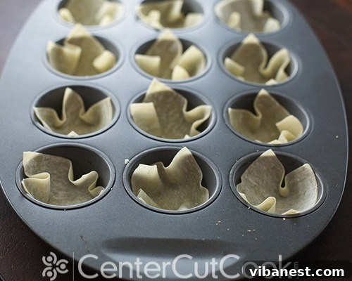 Crispy Wonton Cups Ready for Filling Wonton wrappers carefully pressed into a muffin tin, par-baked to a light golden crisp