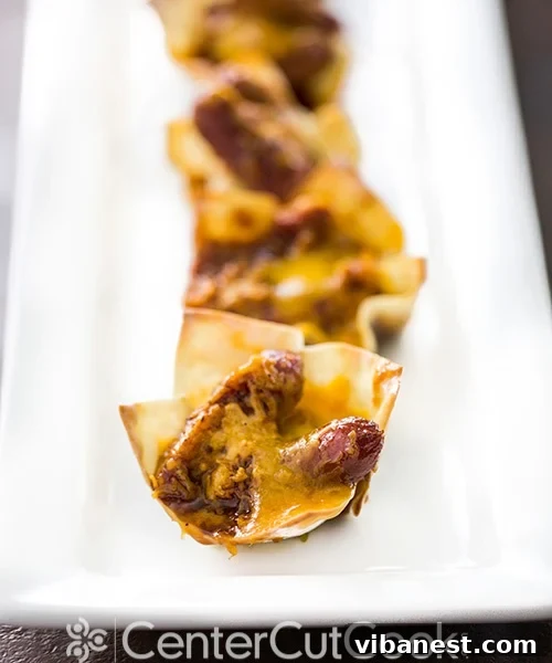 Delicious Cheesy Smokie Cups Hot from the Oven Freshly baked cheesy little smokie cups, golden and bubbly, arranged artfully on a serving tray