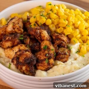 air fryer chicken bites in a bowl with corn and potatoes