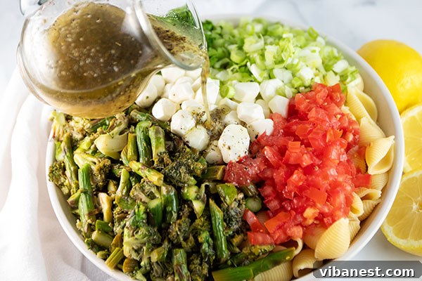 roasted-vegetable-pasta-salad-4.jpg Pasta salad tossed with dressing in a large bowl