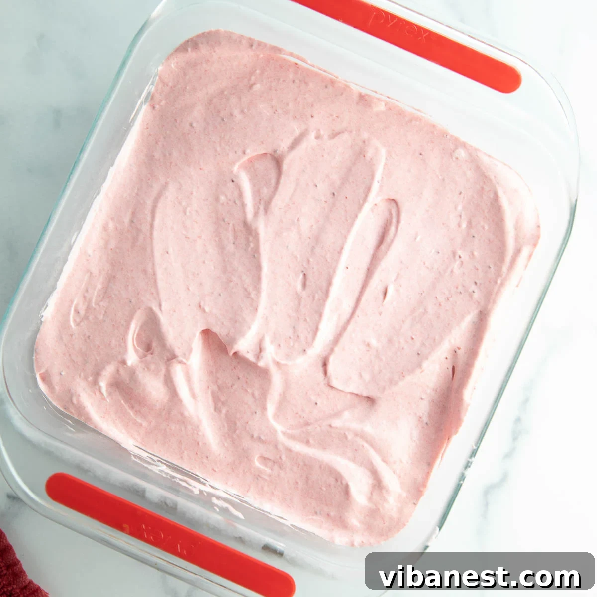 Strawberry Layered Delight 9 Spreading the strawberry cream cheese layer over the cookie crust.