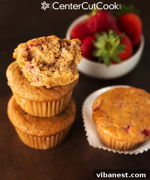 Freshly baked strawberry yogurt muffins cooling on a wire rack.