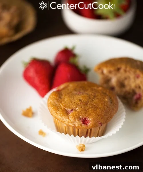 Close-up of a perfectly baked strawberry yogurt muffin showing the light, moist crumb.
