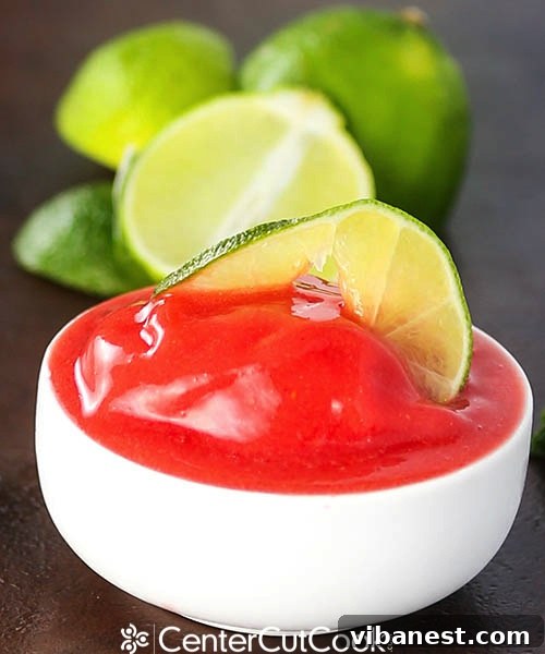 Low Calorie Strawberry Lime Sorbet Delight A beautifully presented bowl of strawberry lime sorbet, garnished with lime zest and a fresh berry, emphasizing its vibrant appearance and healthy appeal