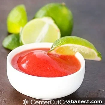 Strawberry Lime Sorbet Ready to Serve A single scoop of vibrant red strawberry lime sorbet presented in a clear glass, ready for immediate enjoyment