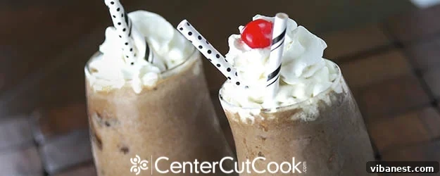 Delicious chocolate peanut butter milkshake in a tall glass with whipped cream and a cherry on top