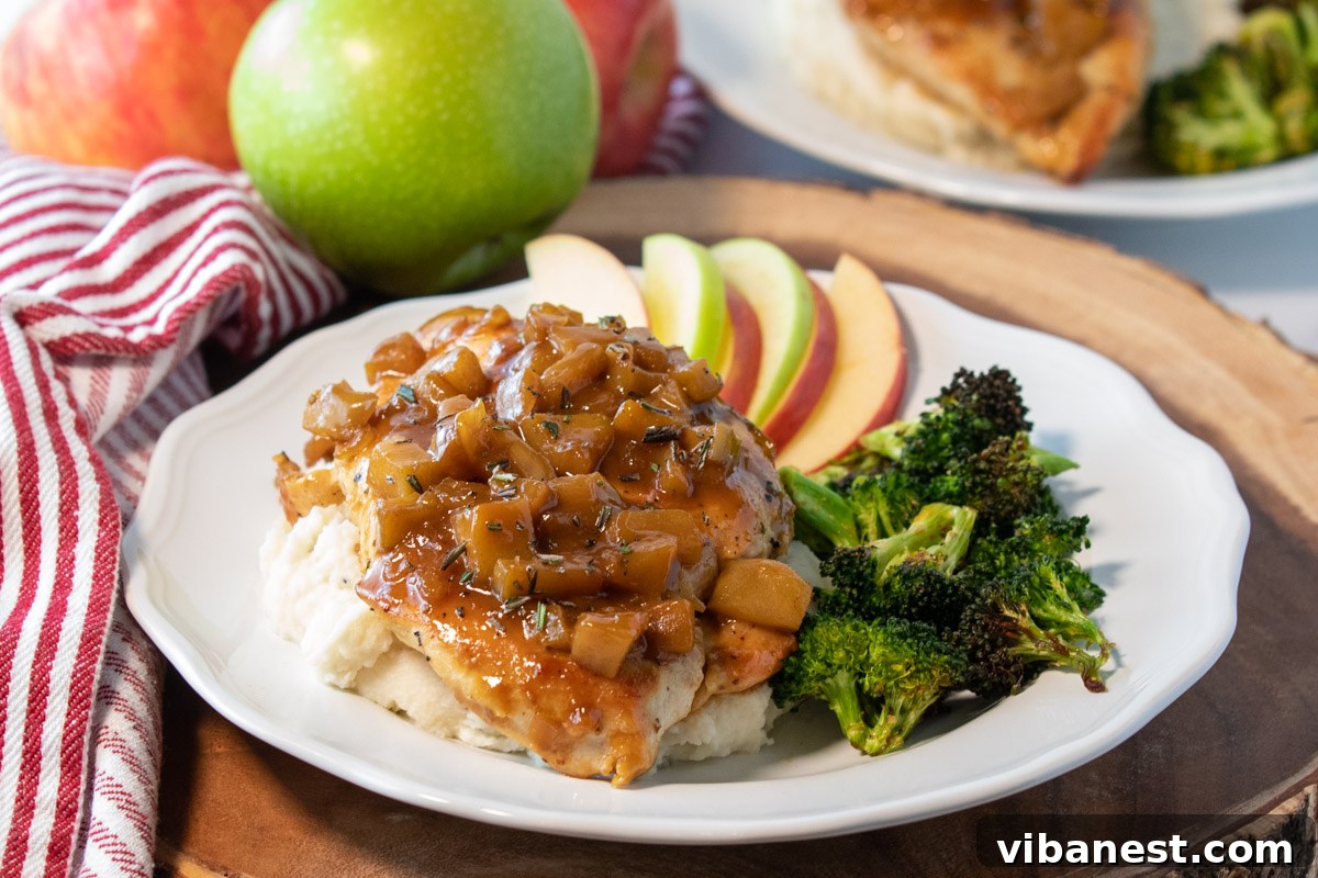 Harvest Skillet Chicken with Apple Cider Glaze 5 A beautifully arranged plate featuring a chicken breast generously covered in apple cider sauce, accompanied by vibrant roasted broccoli florets and golden apple slices, creating a wholesome and appealing meal.