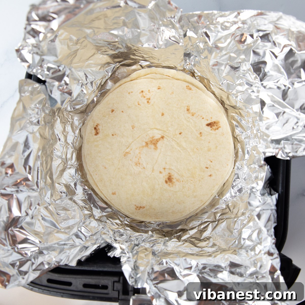 Air Fryer Taco Shells Perfectly Crispy 3 taco shells in foil in air fryer