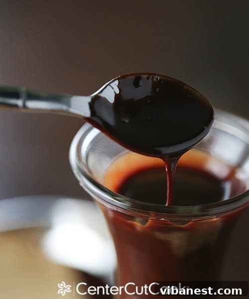 Homemade Hot Fudge Spoonful Closeup of homemade hot fudge with a spoon dipping in, showcasing its thick, glossy, and inviting texture