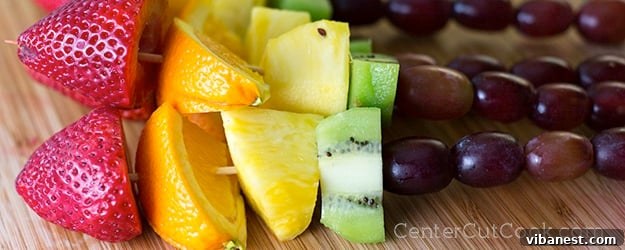 Vibrant rainbow fruit kabobs displayed on a platter