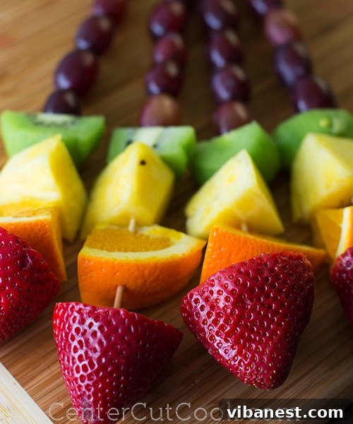 Close-up of Rainbow Fruit Skewers Rainbow Fruit Kabobs on a white plate, showcasing vibrant colors