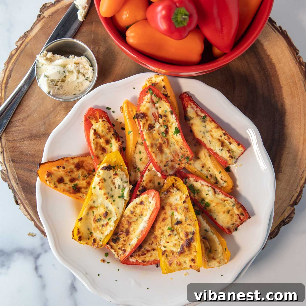 Air Fryer Stuffed Sweet Pepper Bites 2 overhead of plate of air fryer stuffed mini peppers on a plate with bowl of peppers and boursin cheese sitting beside