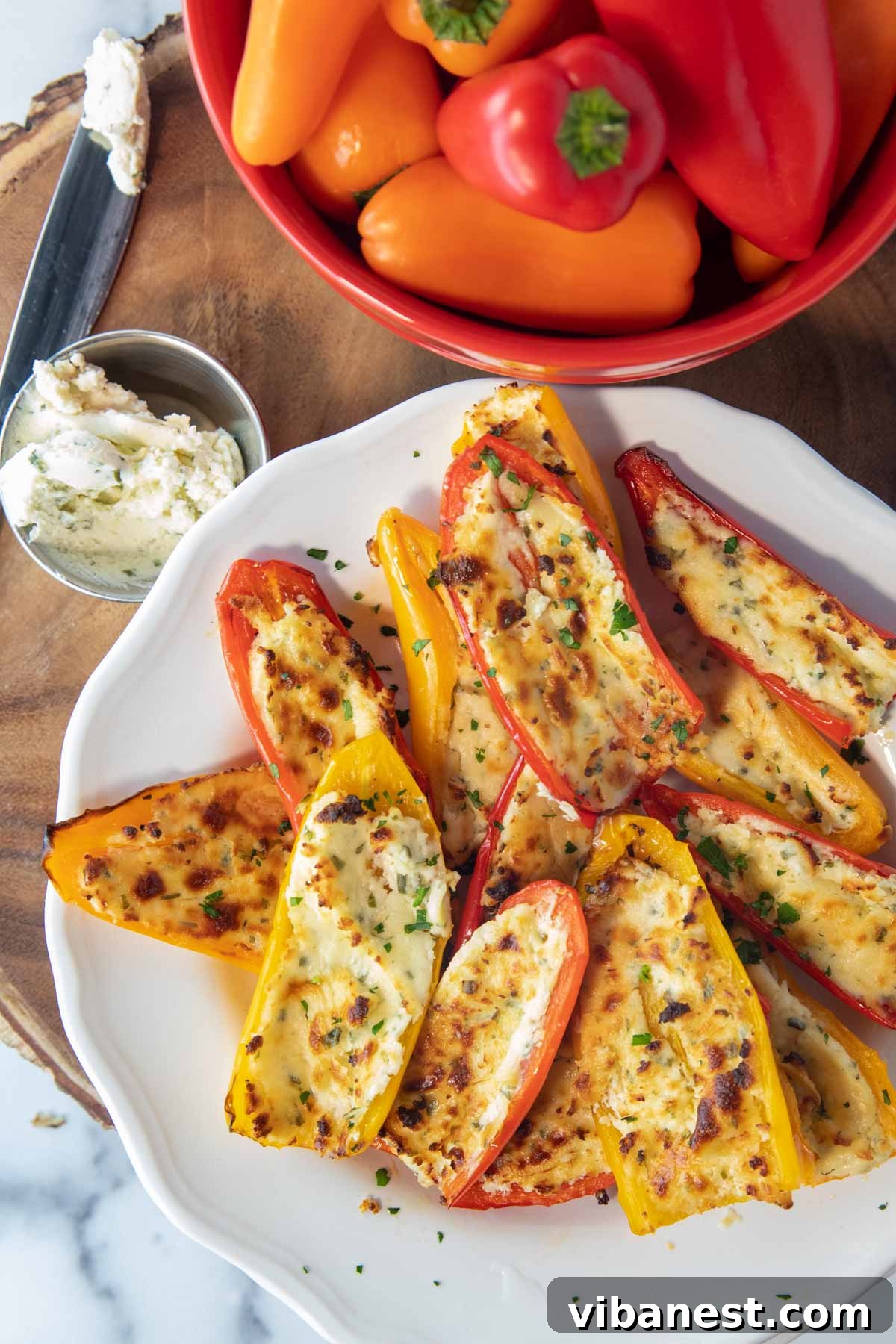 Air Fryer Stuffed Sweet Pepper Bites 5 overhead of plate of air fryer stuffed mini peppers on a plate with bowl of peppers and boursin cheese sitting beside